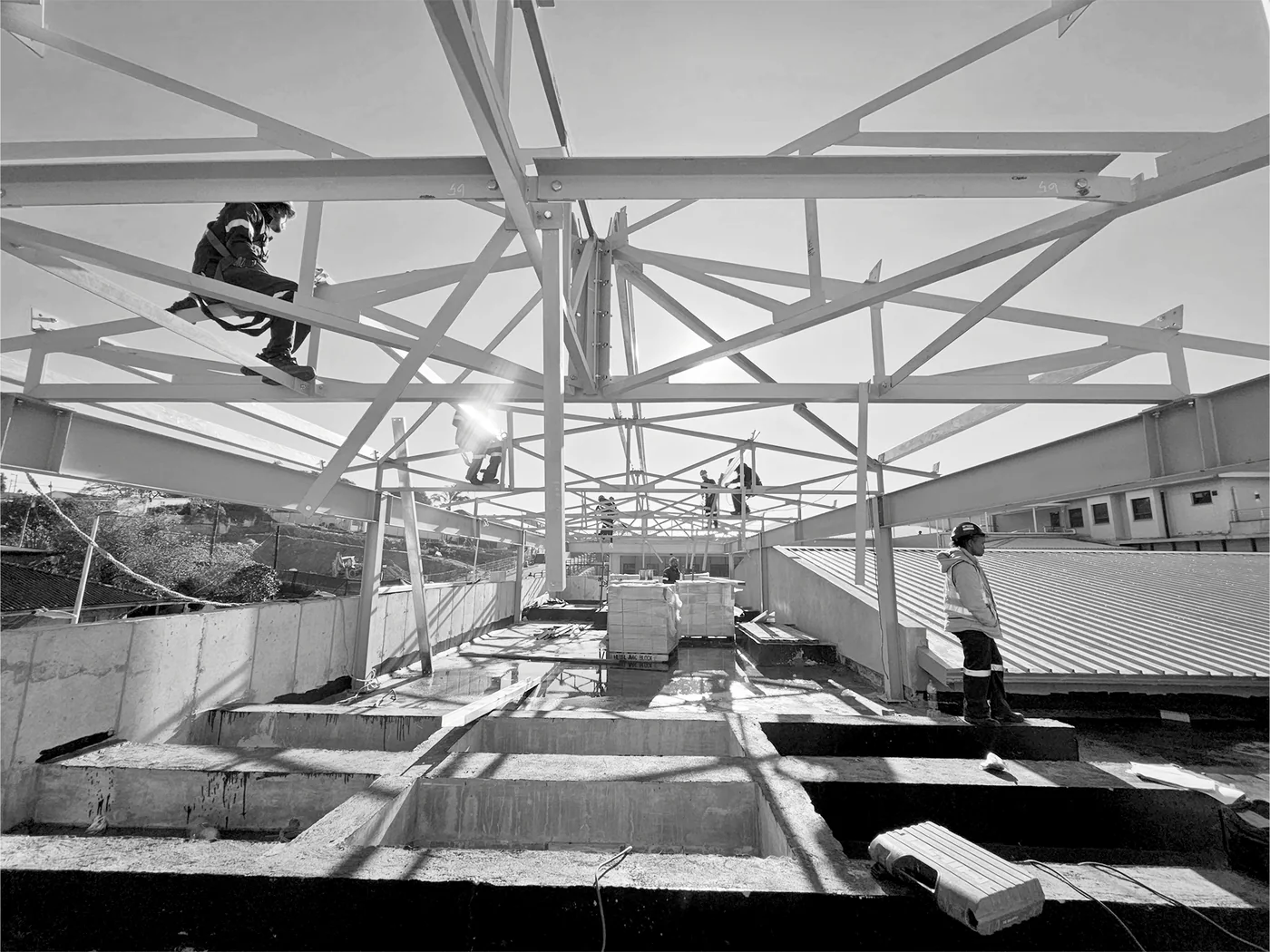 Workers installing structural-steel roof framing